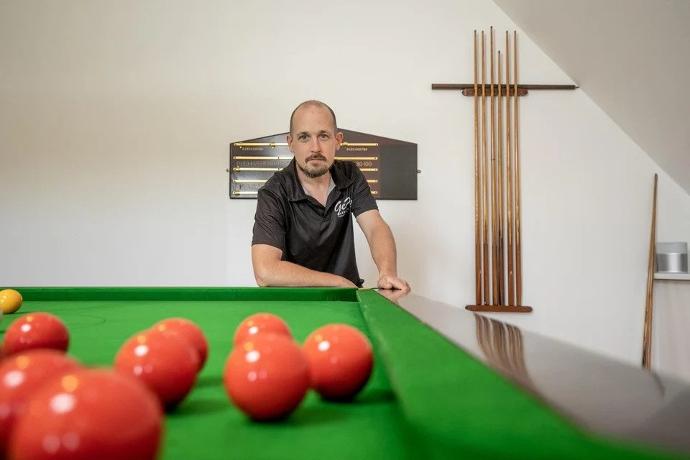 Gert Poseert bij een snookertafel die hij voorzien heeft van nieuw Strachan 6811 laken. Foto genomen door Het Belang van Limburg, Copyrights Joren de Weerdt